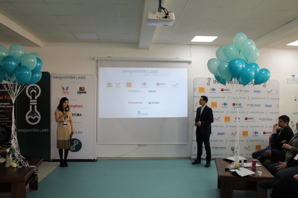 two presenters in front of the presentation screen speaking about the innovation labs programe