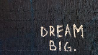 black backround with Dream Big. written on it with chalk